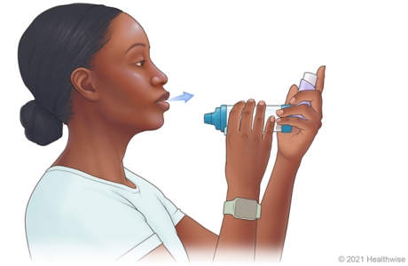 Person tilting head back slightly, holding up spacer near mouth, and slowly breathing out. Person tilting head back slightly, holding up spacer near mouth, and slowly breathing out.
