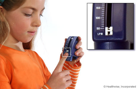A child setting a peak flow meter to its lowest number. A child setting a peak flow meter to its lowest number.