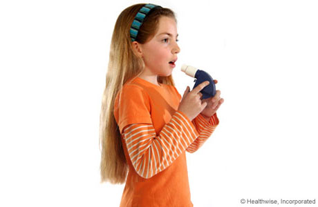 A child taking a deep breath to get ready to use the peak flow meter. A child taking a deep breath to get ready to use the peak flow meter.