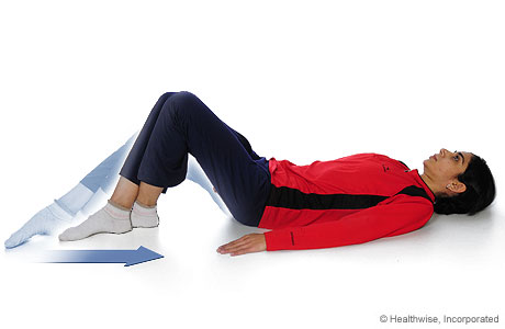 A person doing the knee-flexion-with-heel-slide exercise. A person doing the knee-flexion-with-heel-slide exercise.