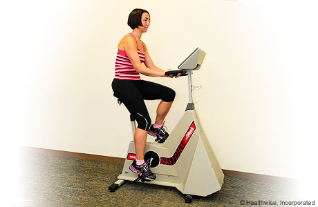 A person exercising on a stationary bike. A person exercising on a stationary bike.