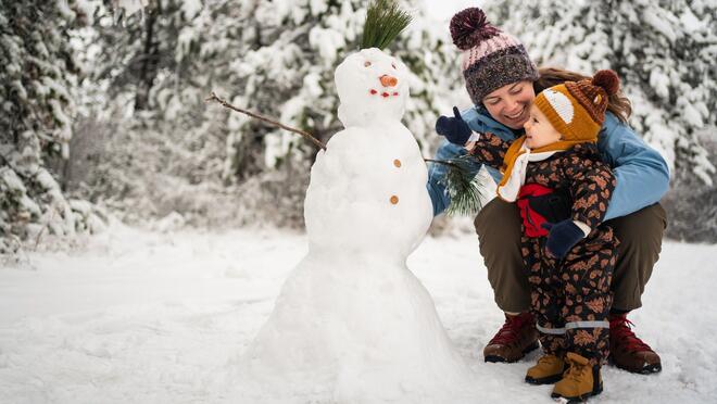 Adult and child building a snowman